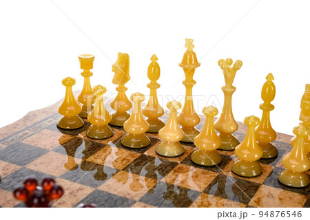 Natural amber different chess pieces figures standing on brown stone board. Close up game concept competition, Classic Gambit Tournament of confrontation. 94876546