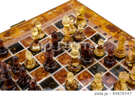 Natural amber different chess pieces figures standing on brown stone board. Close up game concept competition, Classic Gambit Tournament of confrontation. Natural amber different chess pieces figures standing on brown stone board. Close up game concept competition, Classic Gambit Tournament of confrontation. 94876547