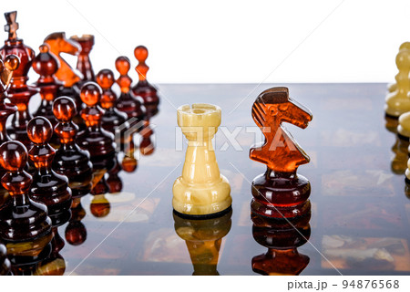Natural amber different chess pieces figures standing on brown stone board. Close up game concept competition, Classic Gambit Tournament of confrontation. Natural amber different chess pieces figures standing on brown stone board. Close up game concept competition, Classic Gambit Tournament of confrontation. 94876568