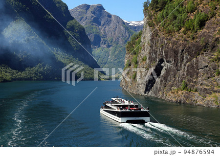 ノルウェーのフィヨルド峡谷を走る遊覧船 94876594