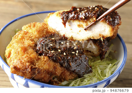 キャベツもたっぷり敷かれている味噌カツ丼を食べる 94876679