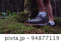 feet teen boy close-up walking on moss in the forest, close-up of the legs of a boy walking in the forest on the grass, cinematic 94877119