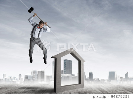 Manager man crashing stone home as symbol for real estate insurance 94879232