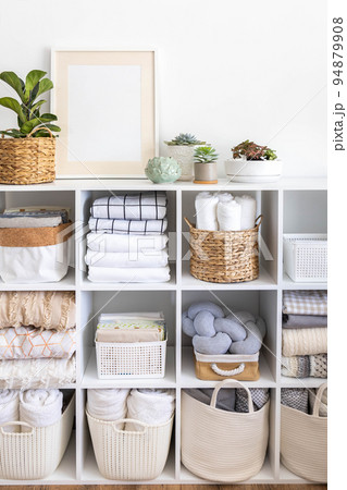 Minimalism Nordic closet shelves neatly folded bed linens and potted plants frame border copy space Minimalism Nordic closet shelves neatly folded bed linens and potted plants frame border copy space 94879908