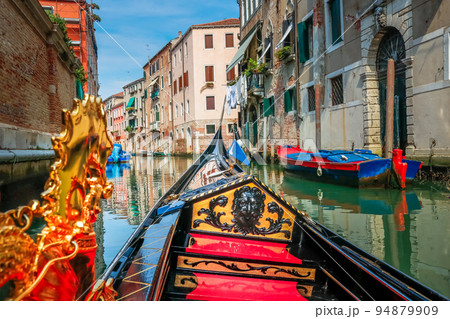 Ornate Gondola in peaceful Canal corner at springtime sunny day, Venice, Italy Ornate Gondola in peaceful Canal corner at springtime sunny day, Venice, Italy 94879909