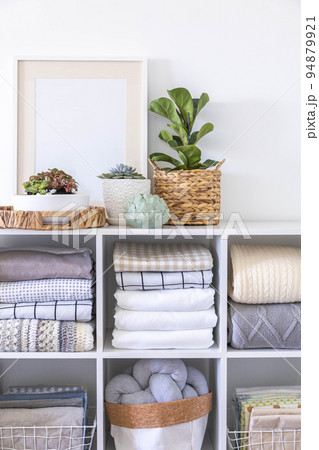 Minimalism Nordic closet shelves neatly folded bed linens and potted plants frame border copy space 94879921