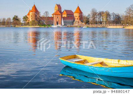 Trakai castle with boat floating on water in foreground, Lithuania 94880147