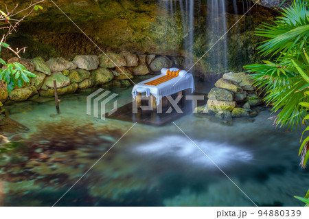 Massage Booth bed in a peaceful corner with lake and waterfall, Cancun, Mexico Massage Booth bed in a peaceful corner with lake and waterfall, Cancun, Mexico 94880339