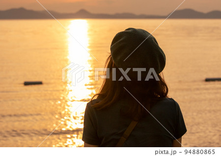 夕暮れ時の猪苗代湖を見る女性 夕暮れ時の猪苗代湖を見る女性 94880865