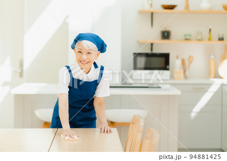 拭き掃除をするハウスキーパーのシニア女性 94881425