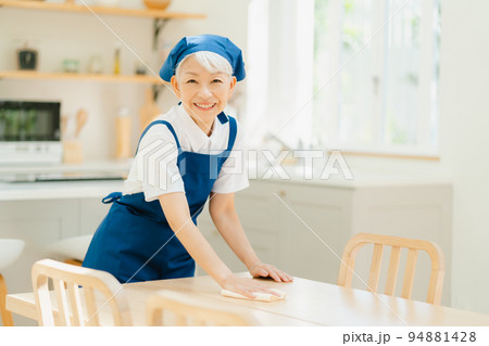 拭き掃除をするハウスキーパーのシニア女性 94881428