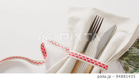 Image of christmas place setting with cutlery and copy space on white background Image of christmas place setting with cutlery and copy space on white background 94881435