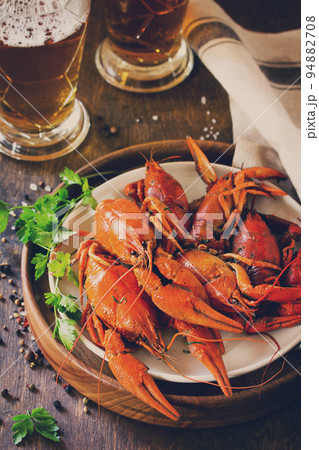 Boiled Crawfish and Fresh Beer in Beakers on a wooden table. Appetizer protein. Toned image. 94882708