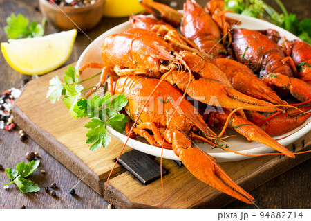 Boiled crawfish, lemon and parsley on a wooden table. Appetizer protein, the concept of healthy eating. Copy space. 94882714