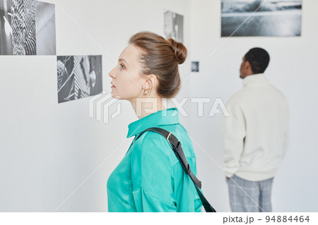 Young Woman Looking at Pictures in Art Gallery 94884464