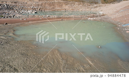 A mountain artificial lake with gray water and dam A mountain artificial lake with gray water and dam 94884478