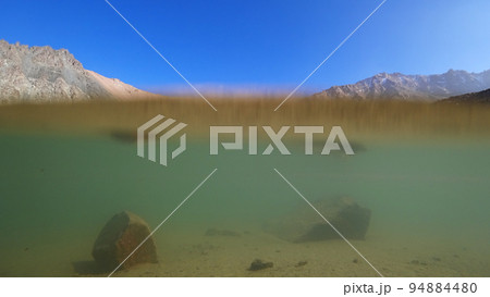 The emerald color of the water of a mountain lake 94884480