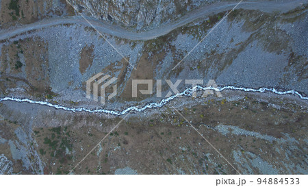 High mountains with a steep cliff and a river High mountains with a steep cliff and a river 94884533