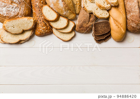 Homemade natural breads. Different kinds of fresh bread as background, top view with copy space Homemade natural breads. Different kinds of fresh bread as background, top view with copy space 94886420