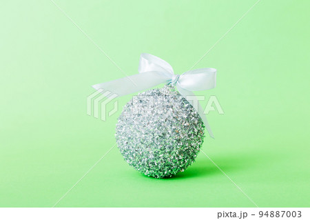 Christmas ball on colored background. decoration bauble with ribbon bow with copy space Christmas ball on colored background. decoration bauble with ribbon bow with copy space 94887003