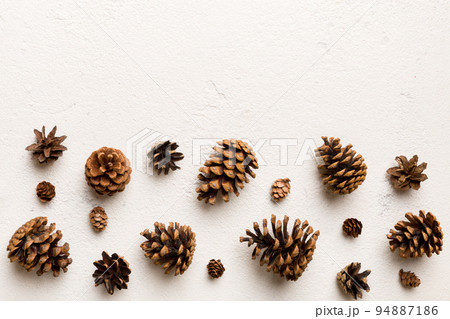 Christmas pine cones on colored paper border composition. Christmas, New Year, winter concept. Flat lay, top view, copy space 94887186