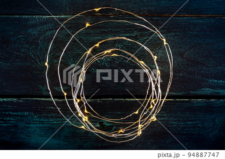 Fairy lights, led garland, overhead flat lay shot on a rustic blue background 94887747