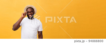 Close up portrait of young afro american shocked tourist , holding his eyewear, wearing tourist outfit, hat, with wide open eyes 94888800