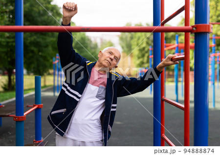 Old man warming up before training outdoors 94888874