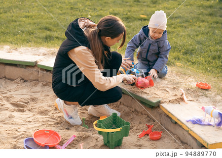 Mother and son playing in sandbox. Little builder. Education, and imagination, purposefulness Mother and son playing in sandbox. Little builder. Education, and imagination, purposefulness 94889770