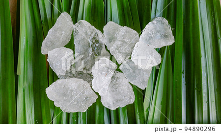 Crystal clear alum cubes or Potassium alum on green leaf Chemical compound substance Concept for beauty spa and underarm treatment industrial                       94890296