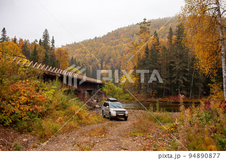 Mitsubishi Pajero at the bridge over a mountain river 94890877