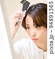 鏡を見ながら自分の髪を染める若い女性　セルフヘアカラー　イメージ 94891365