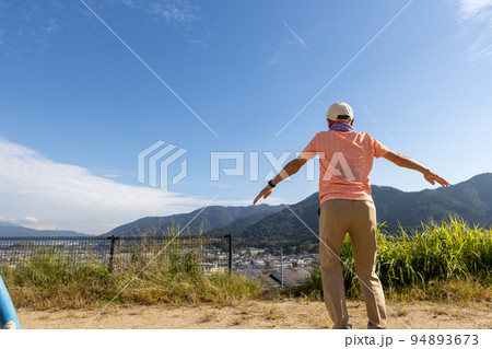 朝の公園で一人でラジオ体操をしているシニア男性 94893673