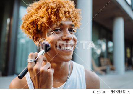 African american visagist holding brush and preparing makeup African american visagist holding brush and preparing makeup 94893818