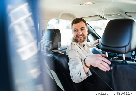 Smiling man driving in reverse on car Smiling man driving in reverse on car 94894117