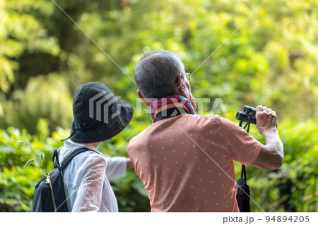 趣味のバードウオッチングをしているシニア男女 94894205