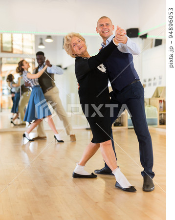 Man and senior woman dancing waltz in studio 94896053