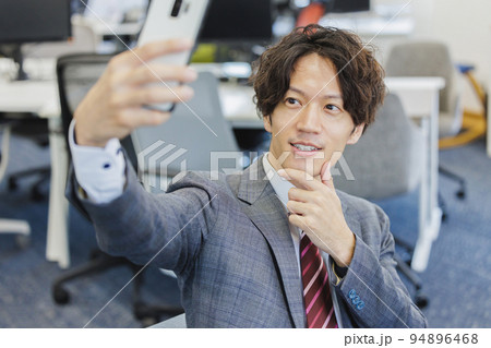 スマートフォンで自撮りをする男性 スマートフォンで自撮りをする男性 94896468