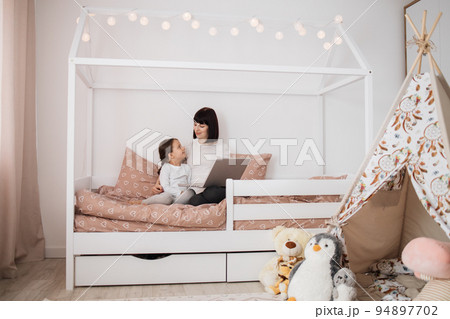 Happy cute daughter and young mother have online video call with father or grandmother using laptop 94897702