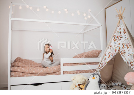 5 years old girl brushing her long hair in her bedroom in the morning. 5 years old girl brushing her long hair in her bedroom in the morning. 94897807