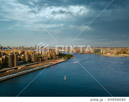 This panoramic view of Manhattan's skyline over the Manhattan Bridge on the Hudson River's horizon is from an aerial point of view of the city This panoramic view of Manhattan's skyline over the Manhattan Bridge on the Hudson River's horizon is from an aerial point of view of the city 94898080