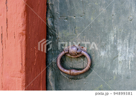 Antique wooden colorful door and lock deteriorated by time and rust in a colonial style house 94899381