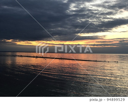 rain cloud with calm sea at sunset, storm is coming rain cloud with calm sea at sunset, storm is coming 94899529