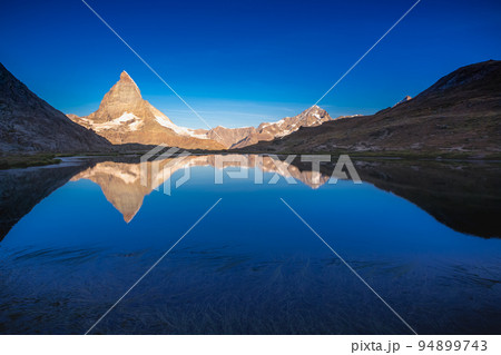 Matterhorn iconic mountain and lake relfection at peaceful sunrise, Swiss Alps 94899743