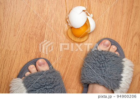 broken egg and feet on the floor in kitchen broken egg and feet on the floor in kitchen 94900206