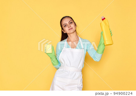 woman in gloves and cleaner apron cleaning with yellow sponge woman in gloves and cleaner apron cleaning with yellow sponge 94900224