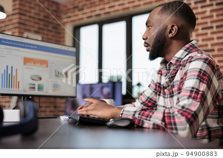 Business manager checking diagrams on computer, analyzing research data information on chars to create startup report and send email. Working remotely from home, doing freelance presentation. 94900883