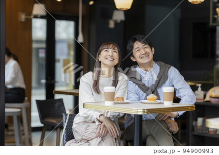 カフェで過ごすミドル夫婦 94900993