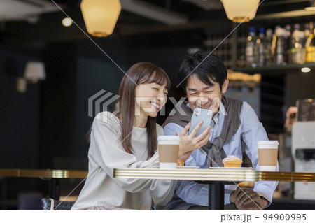 カフェで過ごすミドル夫婦 スマホ カフェで過ごすミドル夫婦 スマホ 94900995