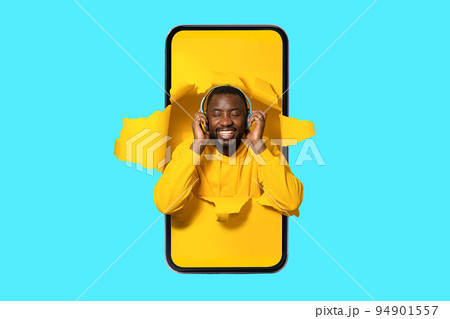 Joyful african american man in smartphone screen wearing wireless headphones and enjoying music with closed eyes Joyful african american man in smartphone screen wearing wireless headphones and enjoying music with closed eyes 94901557